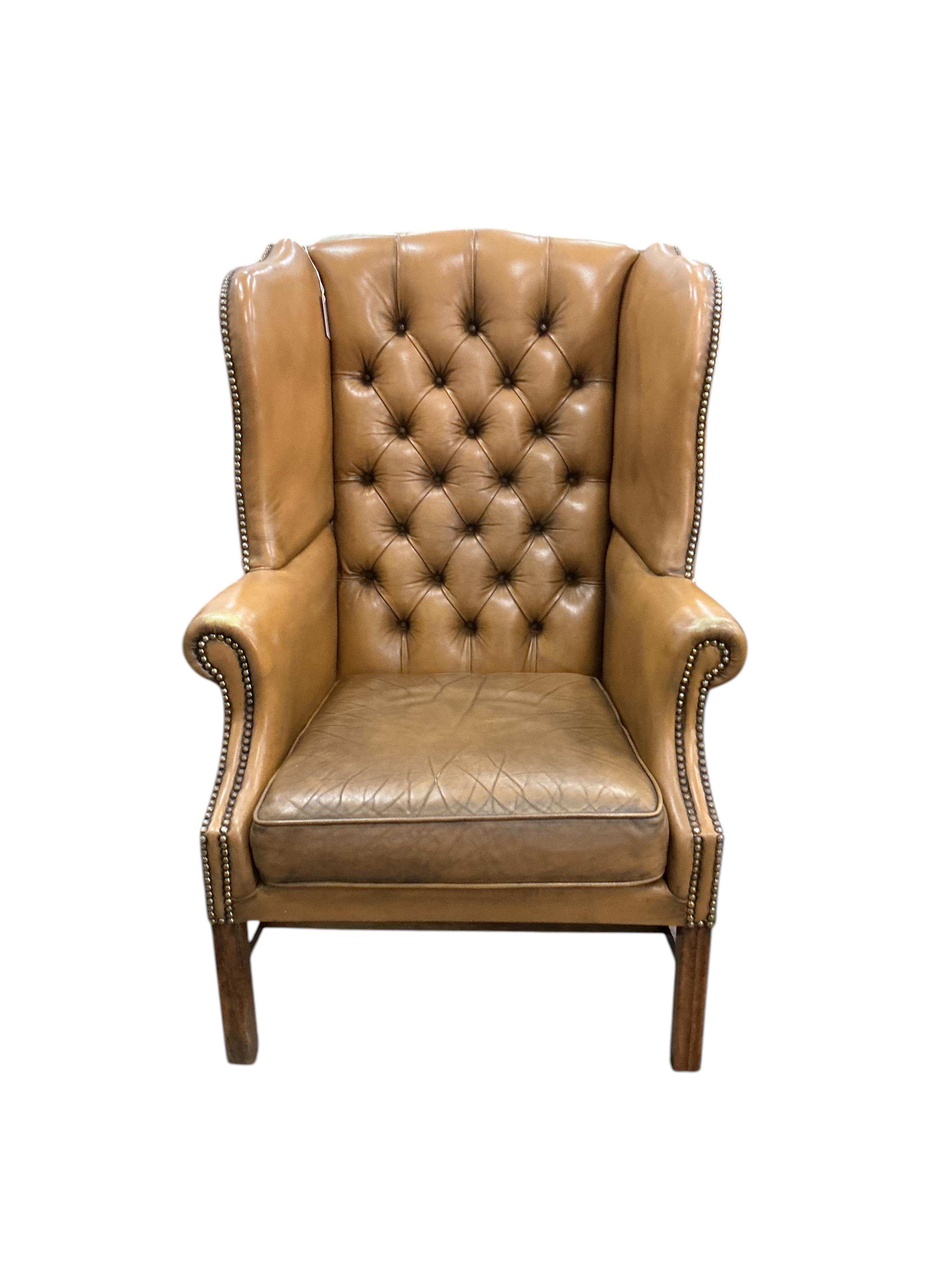 A George III style buttoned tan leather wing armchair, width 74cm, depth 74cm, depth 64cm, height 108cm